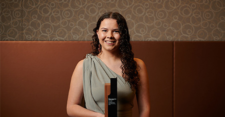 Dhani Gilbert holding her Austcover Young Landcare Leadership Award