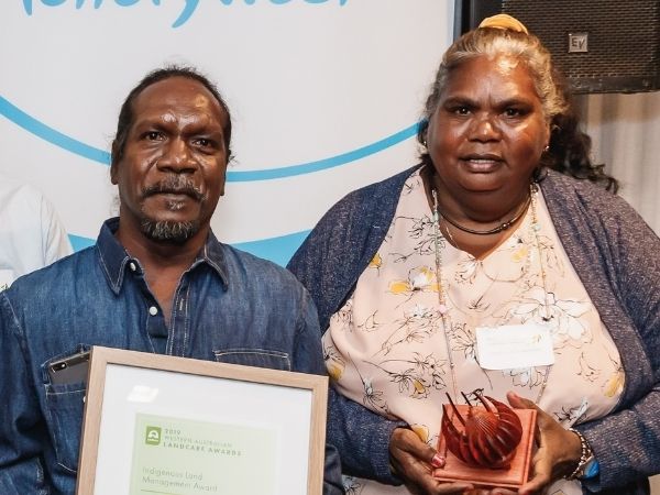 Aboriginal Woman and Man standing holding an award