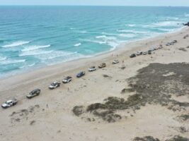 cars driving on coastal sand